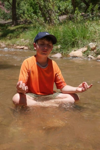 Aidan pretending to meditate in the creek