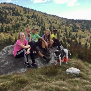 Kids on rock in meadow