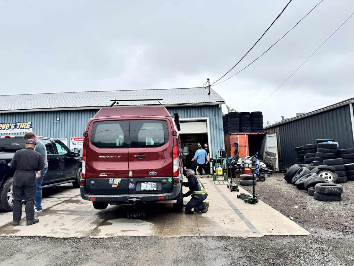 man fixing tire on van